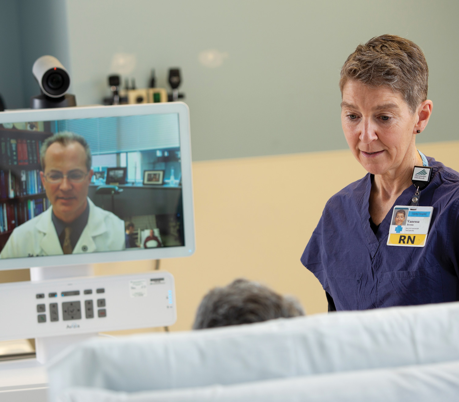 Keith McAvoy, MD, medical director of the teleNeurology service and section chief of general neurology at Dartmouth Hitchcock Clinics Manchester (shown on screen) consults with a bedside clinician and a patient via a telehealth cart. (Photo taken prior to COVID-19 protocols.)