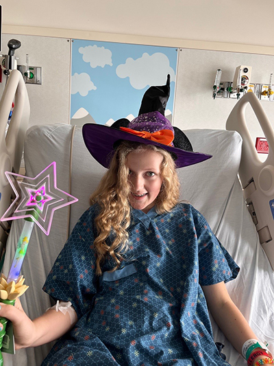 Katherine in her Halloween costume during "reverse trick-or-treating," where nurses, the Child Life team, and others visit hospital beds and give patients treats.