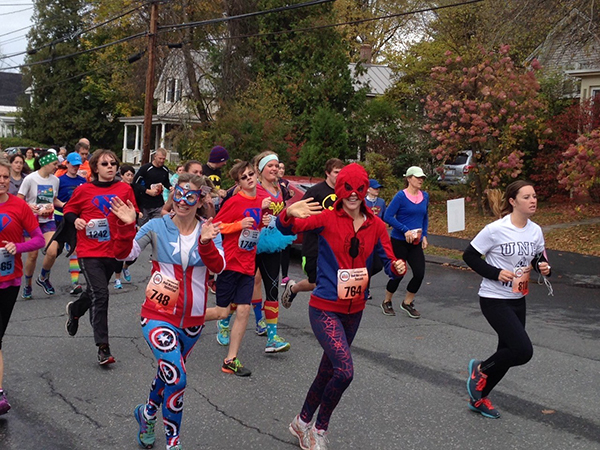 Susie Matter (dressed as Spiderwoman, center) running with her friend (dressed as Captain America, left) at the CHaD HERO in Hanover, N.H.
