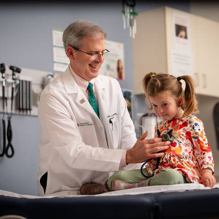 Keith J. Loud is checking a young gurls with a stethoscope
