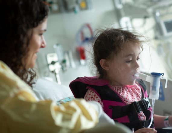 Child in hospital room getting assistance breathing