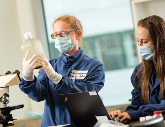 Two researchers examine a specimen in a laboratory.