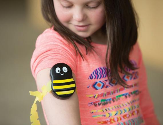 Child with bumblebee decoration on arm