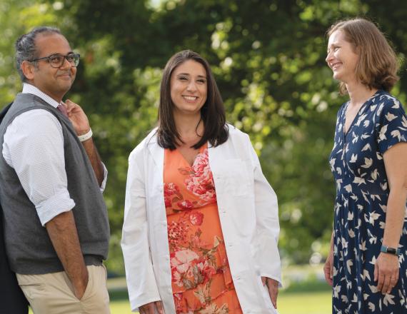 Four years after participating in the inaugural session of Dartmouth Health Care Foundations (DHCF), Jaclyn Engel (center) was welcomed into the Geisel School of Medicine Class of ’26. DHCF co-leaders Manish Mishra MED’05, MPH’09 (left) and Elizabeth Carpenter-Song, PhD, D’01 (right) attended Engel’s White Coat Ceremony.