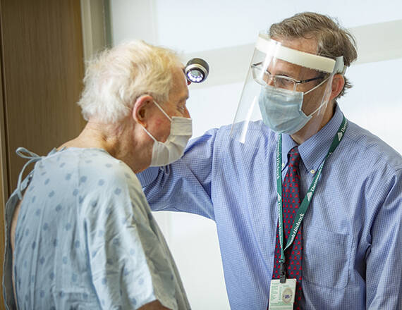 Caregiver providing support to patient in hospital gown