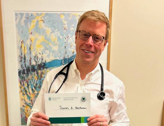 James A. Heckman proudly holding his honored caregiver recognition and pin