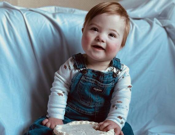 Small child sitting on a bed